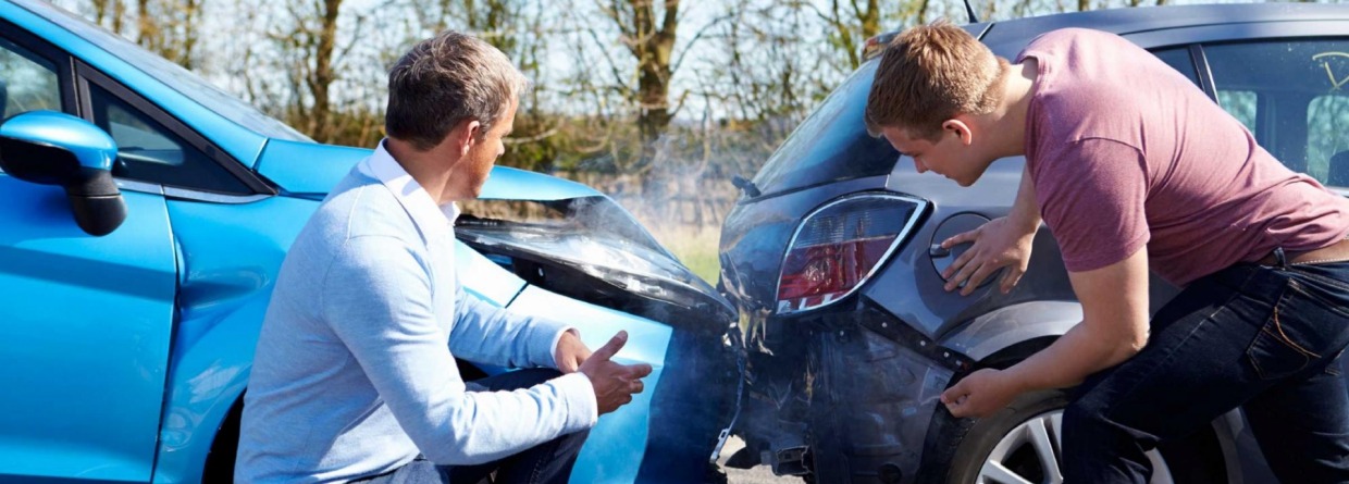 2 mannen bekijken de schade aan hun auto,s 