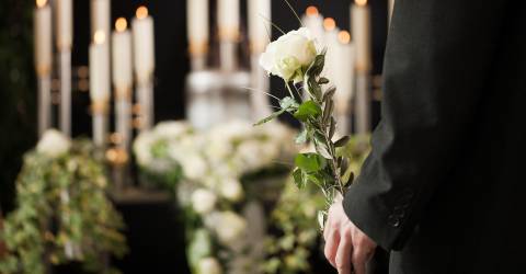 uitvaart, bloemen, kaarsen, man met bloem